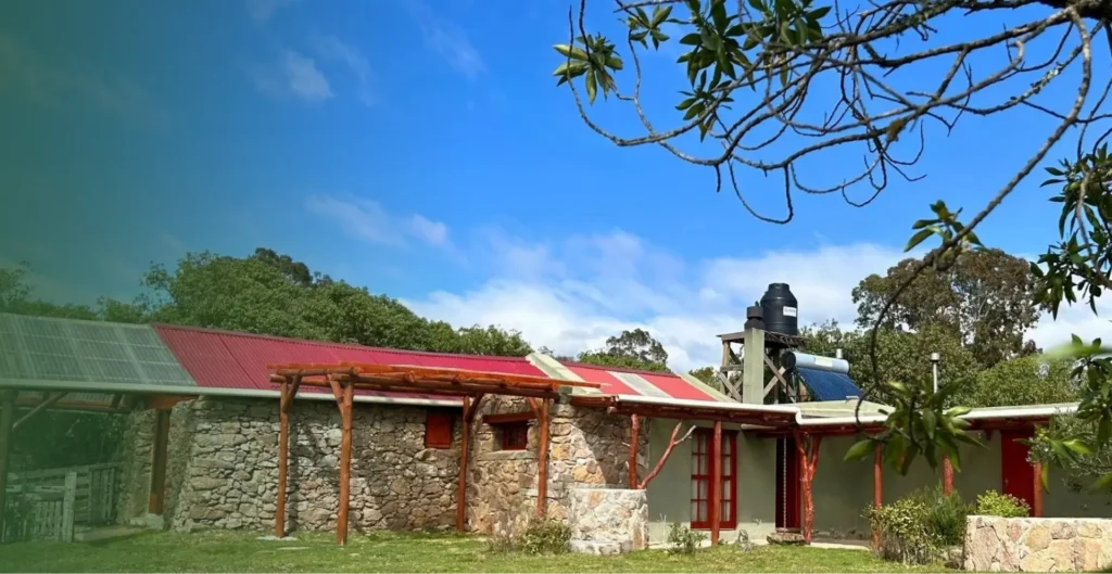 Casa Gaucho con techo rojo entre árboles