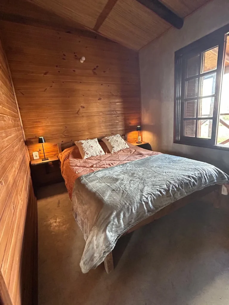 Dormitorio con cama matrimonial en la Cabaña Entre Lagos