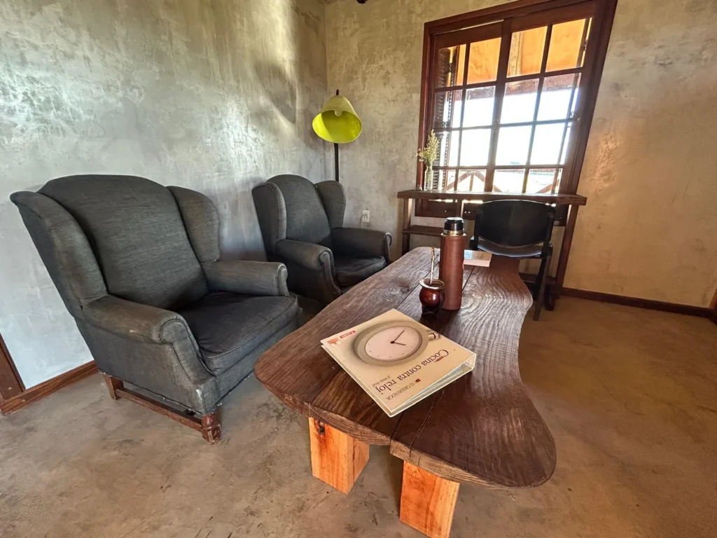 Sillones y mesa baja de madera junto a la ventana de la Cabaña Entre Lagos