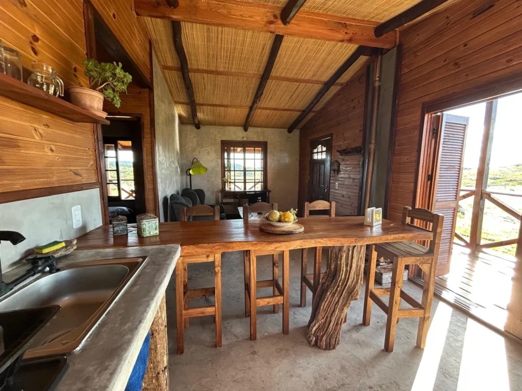 Cocina y mesa de comedor con salida al deck en la Cabaña Entre Lagos
