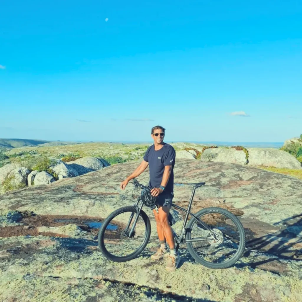 Ciclista sobre una roca con vista a las sierras de 7 Generaciones